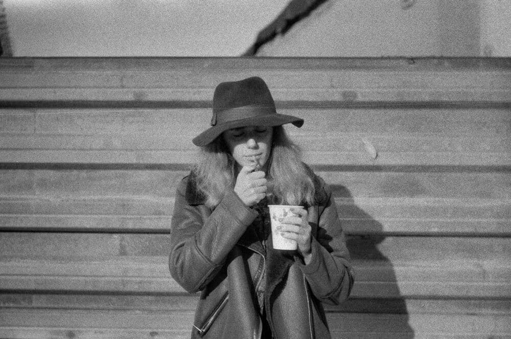 woman in coat holding cup