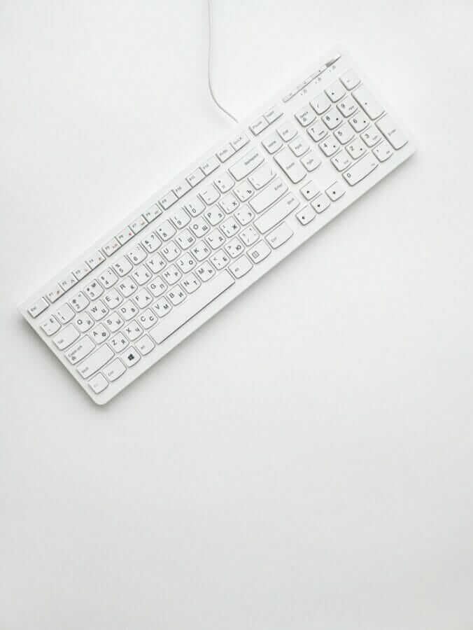 white corded computer keyboard on white surface