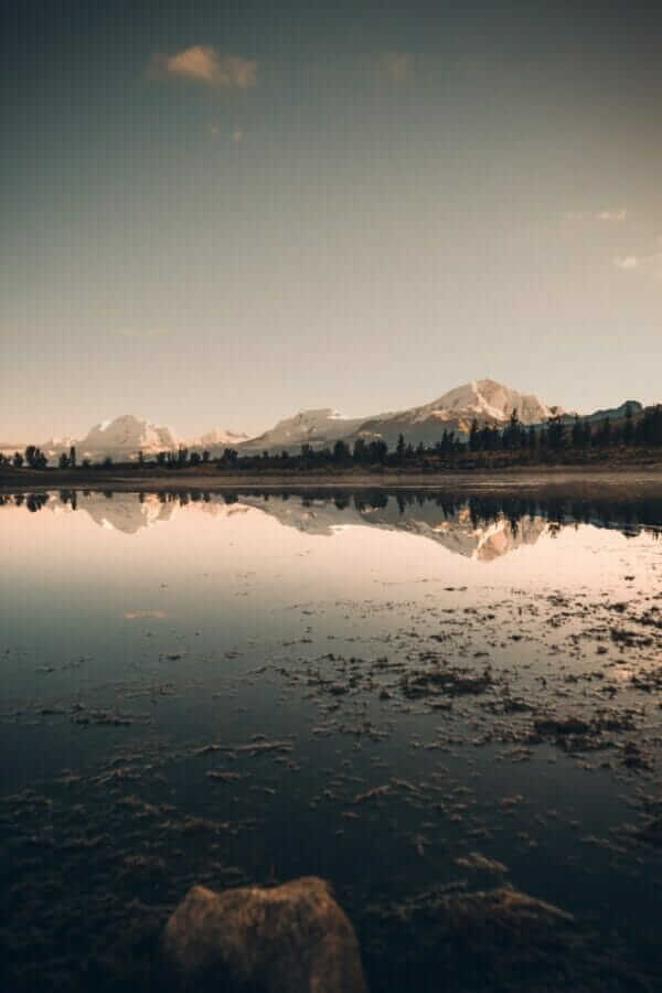 lake near mountain under blue sky during daytime