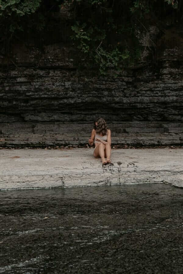 woman in black bikini sitting on white plastic chair