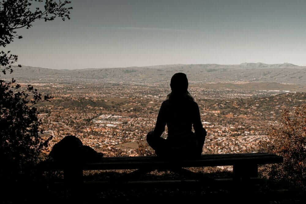a person sitting on a bench overlooking a city