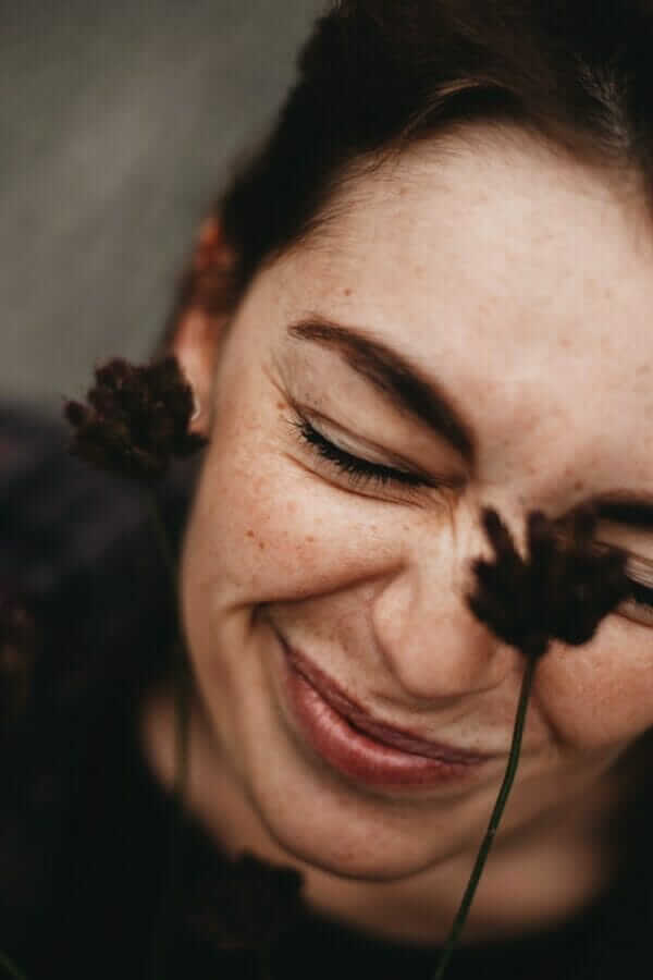 Lady with closed eyes with flowers near face