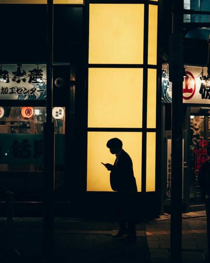 a person standing in front of a building at night