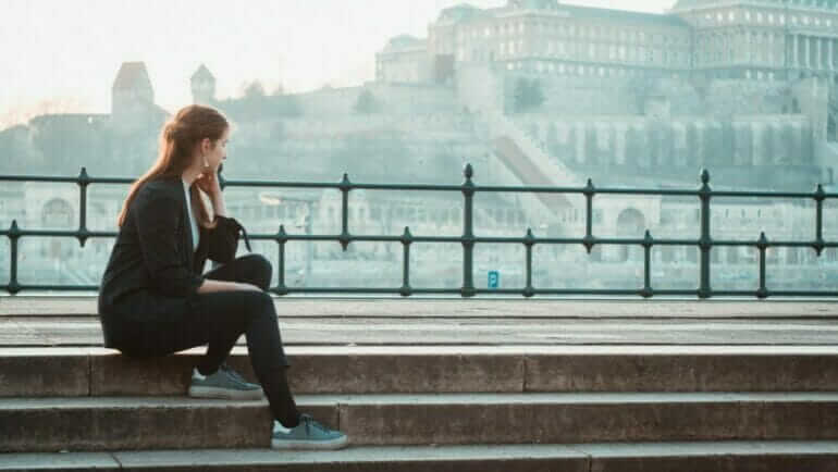 woman sitting on stairs at park during daytime