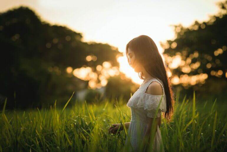 Ne laissez jamais votre peur décider de ce que sera votre avenir shallow focus photography of woman standing on grass field while holding grass