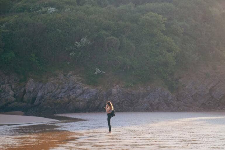 Retrouver l'estime de soi après une rupture woman in black dress walking on brown sand near body of water during daytime