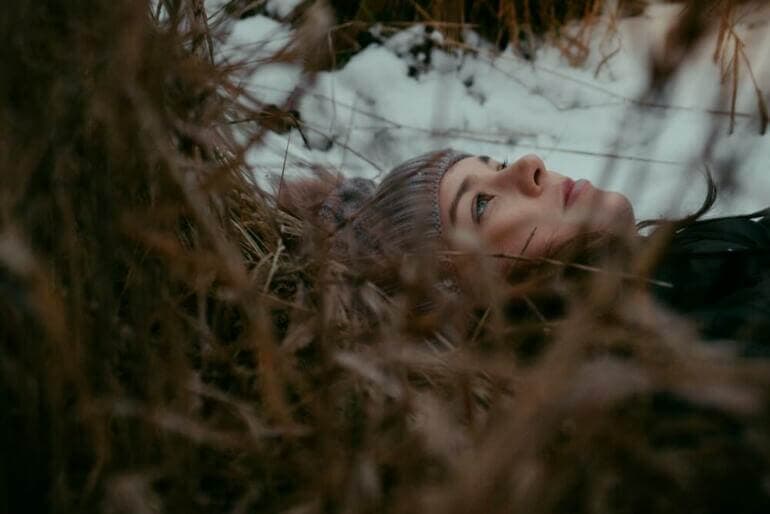 Chaque personne est coupable de tout le bien qu'elle n'a pas fait. a woman is laying down in the snow