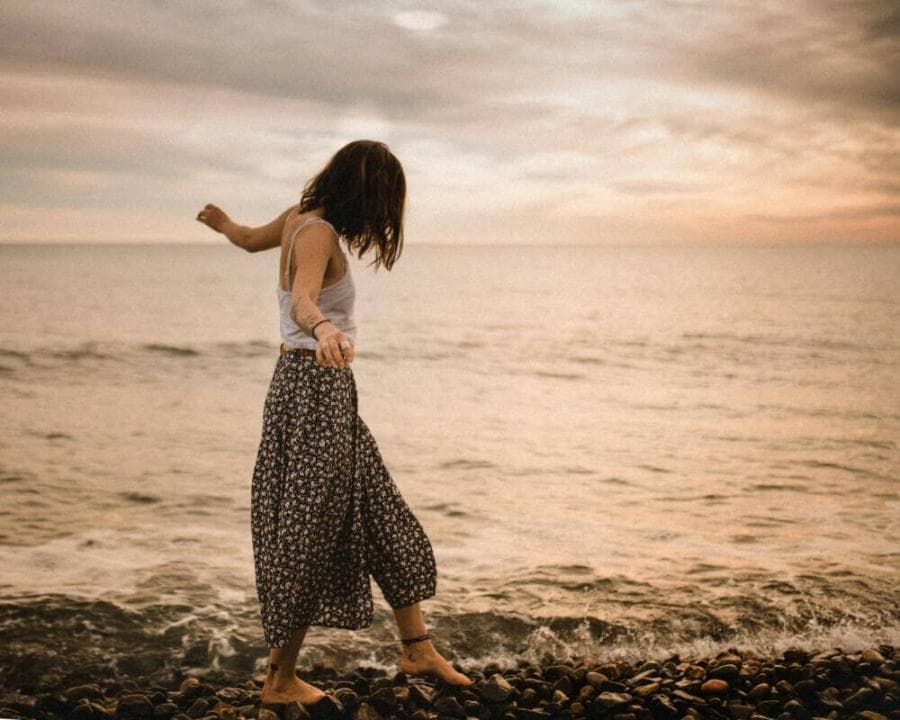 woman walking on rocks in beach