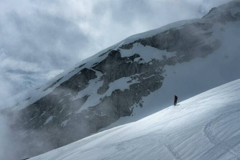 L'échec est-il vraiment une fin ? person in red jacket and black pants standing on snow covered mountain during daytime