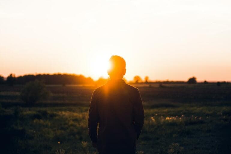 8 Stratégies Proactives pour Transformer la Solitude en Sérénité silhouette of man facing sunset