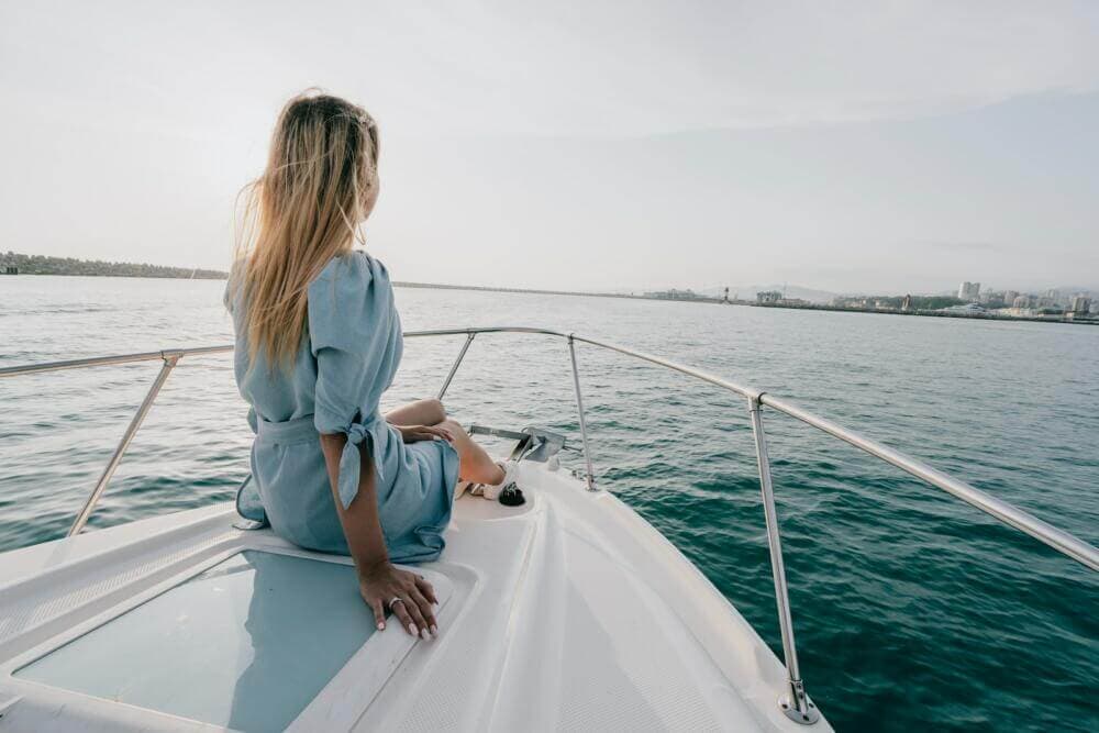 woman in white long sleeve shirt sitting on white boat during daytime