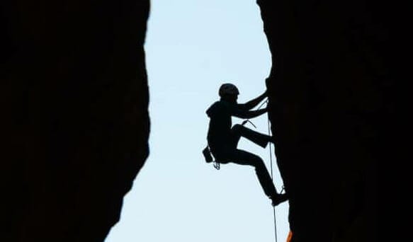 a man climbing up the side of a mountain
