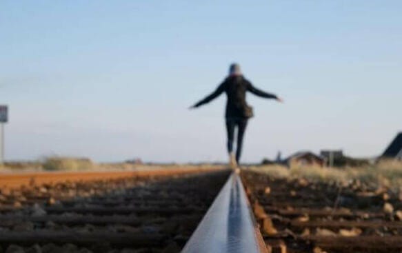 woman walking on train railway
