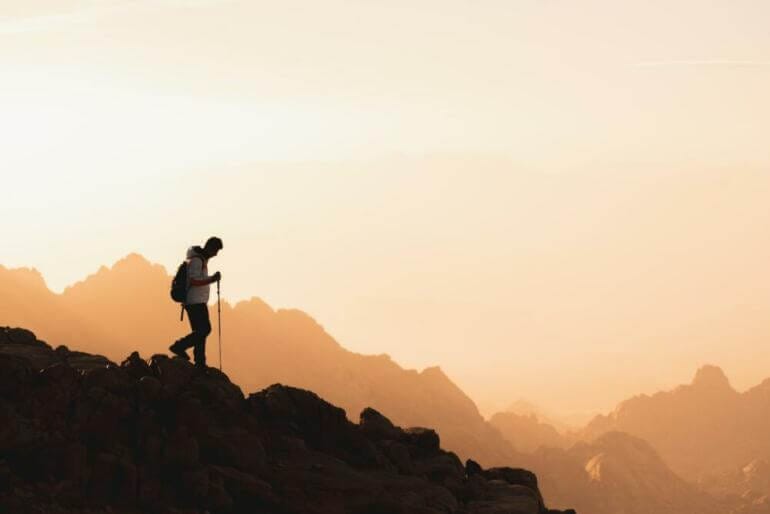 a couple of people standing on top of a mountain