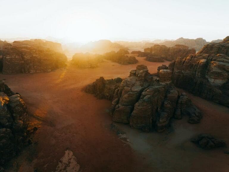 "Commencez par l'obscurité : Leçons de vie de Léonard de Vinci pour illuminer votre chemin" the sun is setting over a rocky landscape