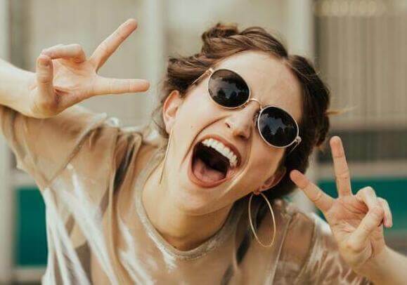 selective focus photography of jolly woman using peace hand gesture