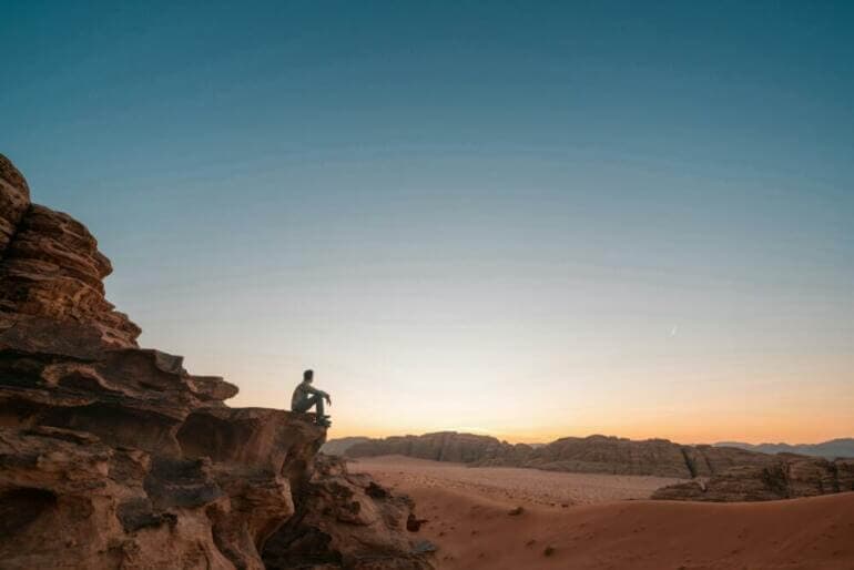Choisir la sincérité : Libérez votre véritable beauté intérieure a man sitting on a rock in the desert