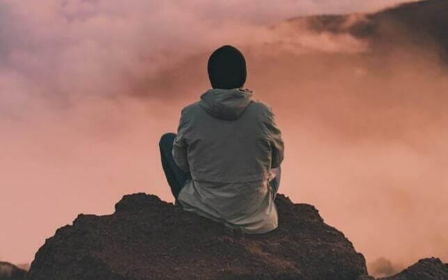 man sitting on cliff