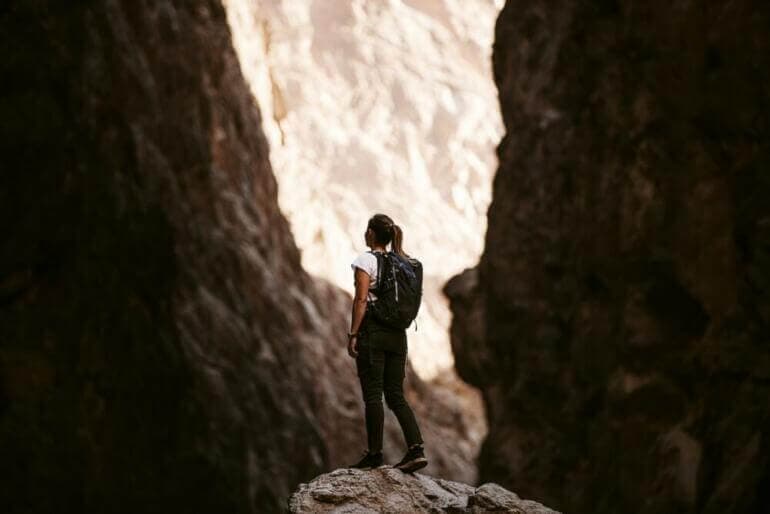 Libérez-vous de la comparaison : découvrez le pouvoir de l'authenticité personnelle a person standing on a rock in a canyon