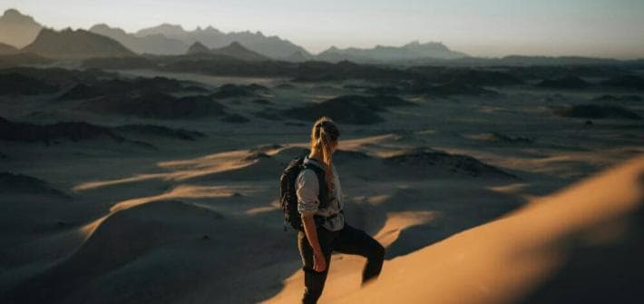 La Feuille Verte et l'Esprit : Comprendre l'Interdépendance de la Perception et de la Réalité a woman standing on top of a sand dune