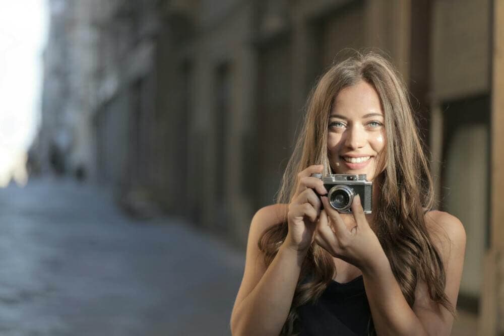 Woman in Black Tank Top Holding Black and Silver Camera