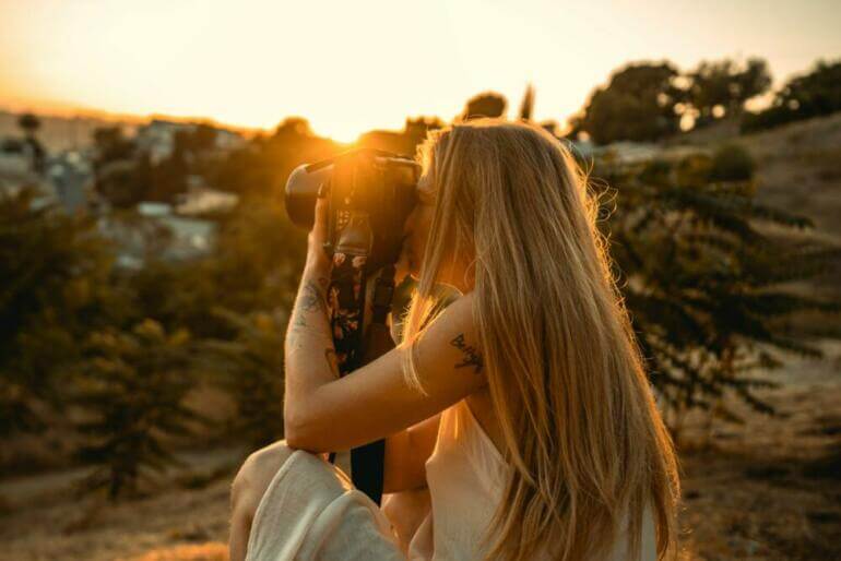 A couple of women sitting on top of a hill