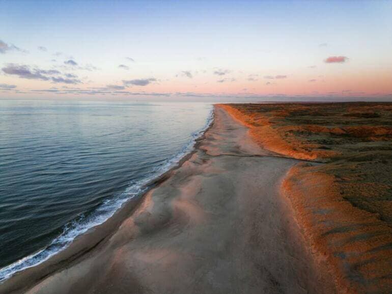 Comment visualiser pour manifester : Guide pratique et complet An aerial view of a beach at sunset