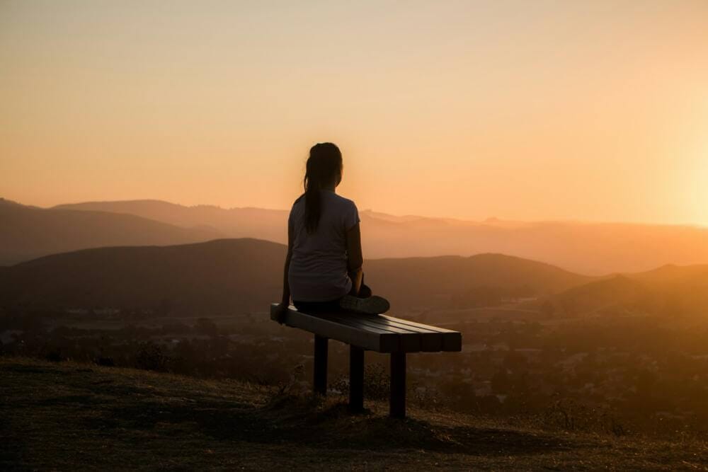 Exercices Simples pour Être Présent woman sitting on bench over viewing mountain